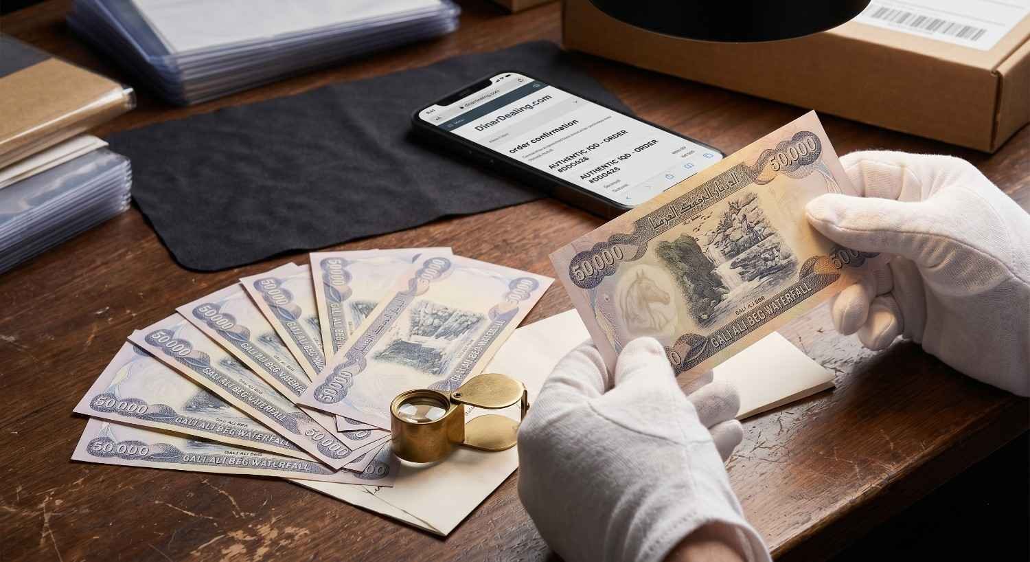 Gloved hands inspect an authentic Iraqi Dinar banknote.